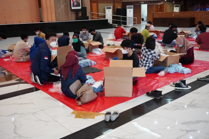 Youth Organization members pack vitamins and maskers for distribution